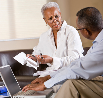 Senior African American couple paying bills online